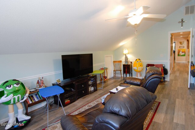 living room with hardwood / wood-style flooring, vaulted ceiling, and ceiling fan