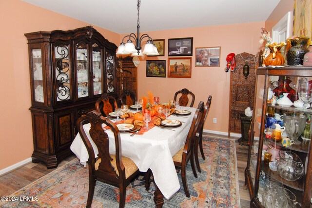 dining space with wood-type flooring and a chandelier