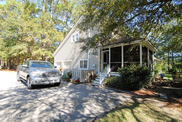 view of front of house featuring a garage and a sunroom