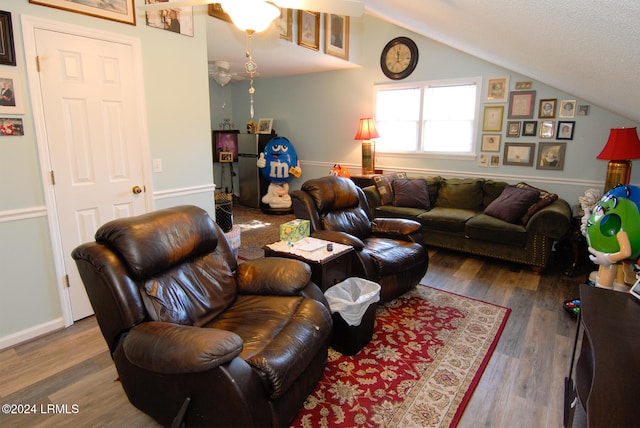 living room featuring vaulted ceiling, hardwood / wood-style floors, and a textured ceiling