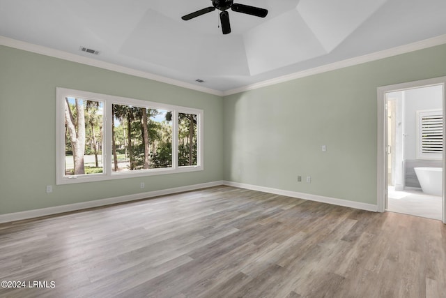 unfurnished room featuring ornamental molding, ceiling fan, light hardwood / wood-style floors, and a tray ceiling