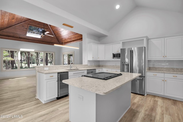 kitchen featuring white cabinetry, stainless steel appliances, kitchen peninsula, and a kitchen island