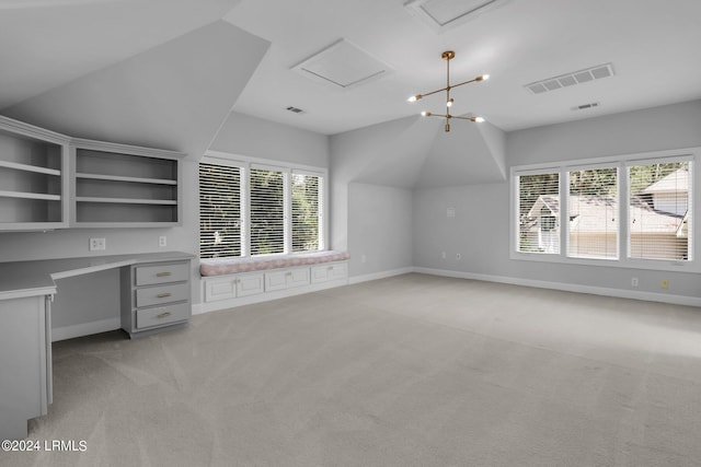 unfurnished office featuring built in desk, lofted ceiling, and light carpet