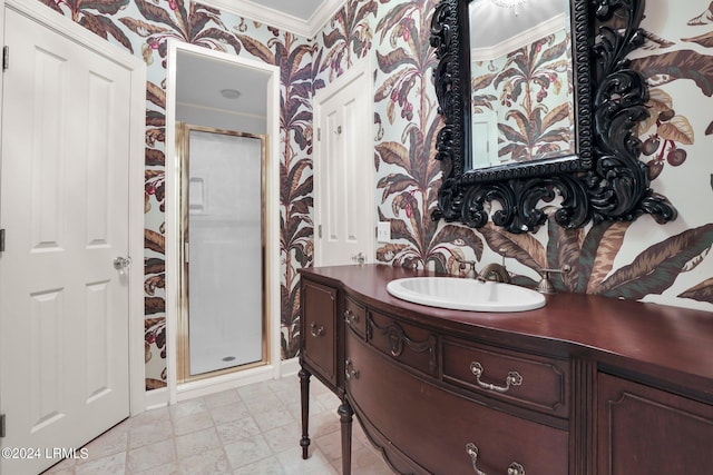 bathroom with crown molding, vanity, and a shower with shower door