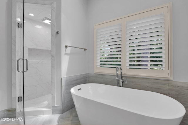 bathroom featuring shower with separate bathtub