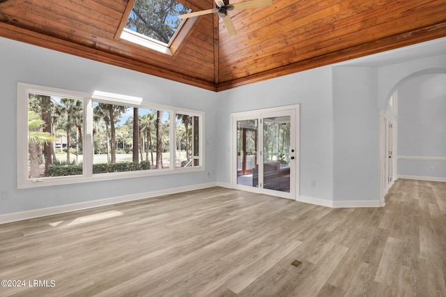 spare room featuring a healthy amount of sunlight, wooden ceiling, high vaulted ceiling, and a skylight