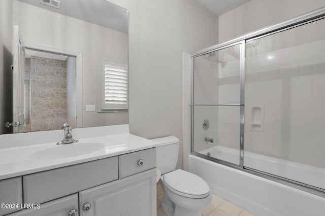 full bathroom featuring vanity, toilet, tile patterned flooring, and combined bath / shower with glass door