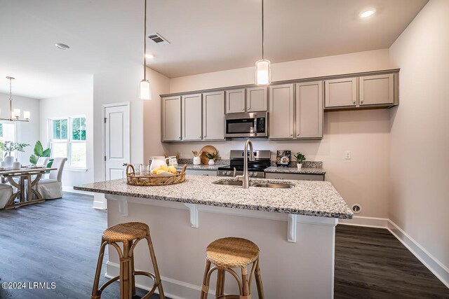 kitchen featuring stainless steel appliances, gray cabinets, sink, and light stone counters