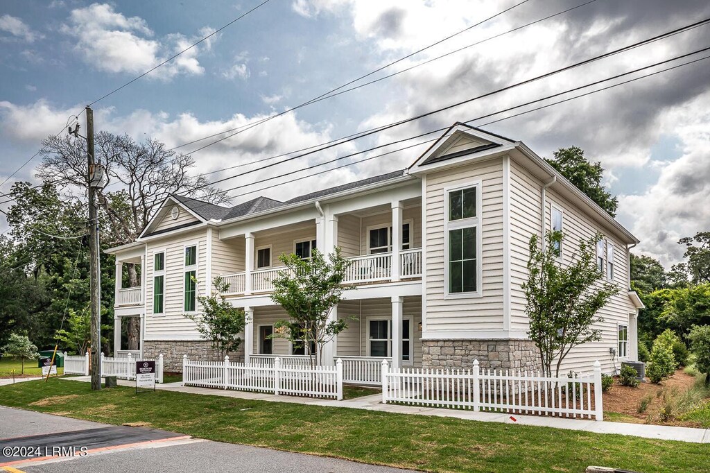 view of front of home featuring a balcony and a front yard