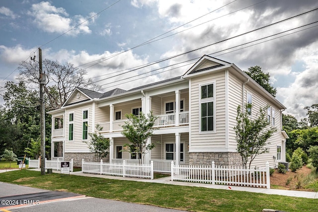 view of front of home featuring a balcony and a front yard