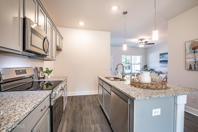 kitchen featuring sink, a kitchen island with sink, stainless steel appliances, dark hardwood / wood-style floors, and light stone countertops