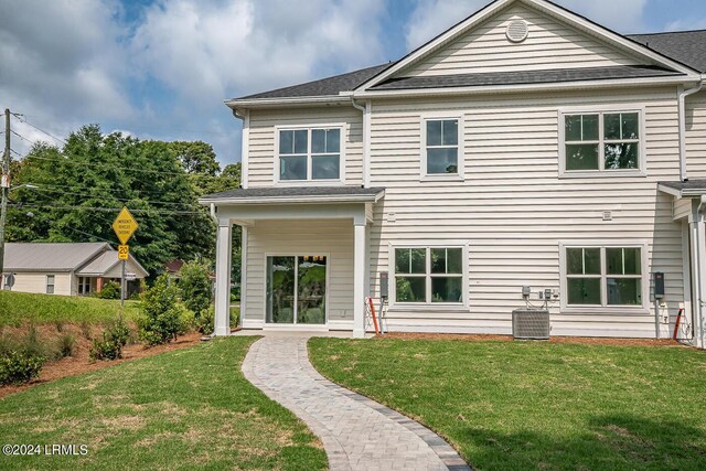 view of front of house with a front yard and central air condition unit