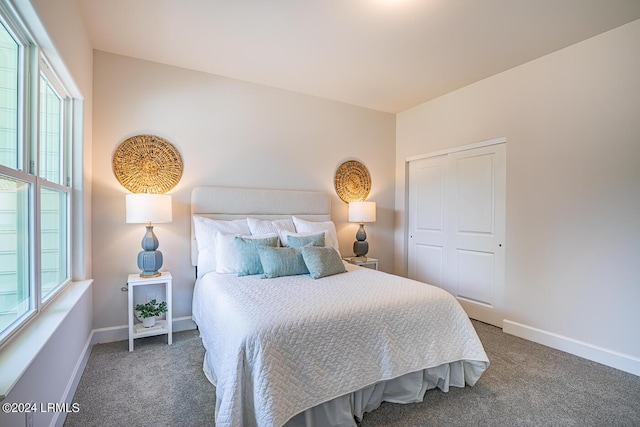 bedroom with dark carpet and a closet