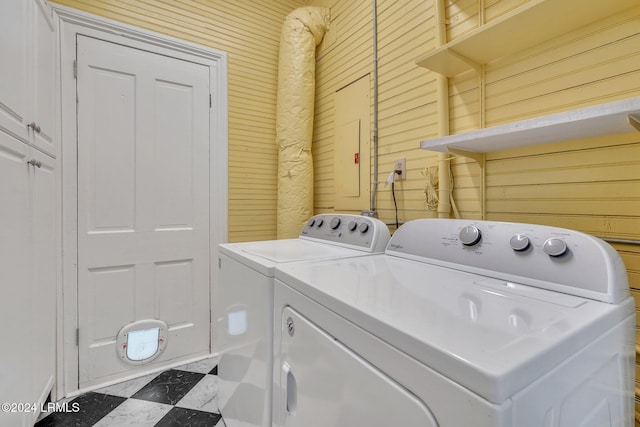 laundry room featuring cabinets, separate washer and dryer, and wooden walls