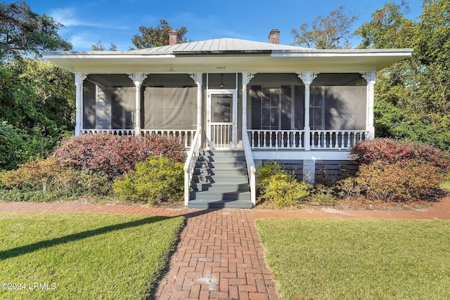 bungalow with a front lawn and a sunroom