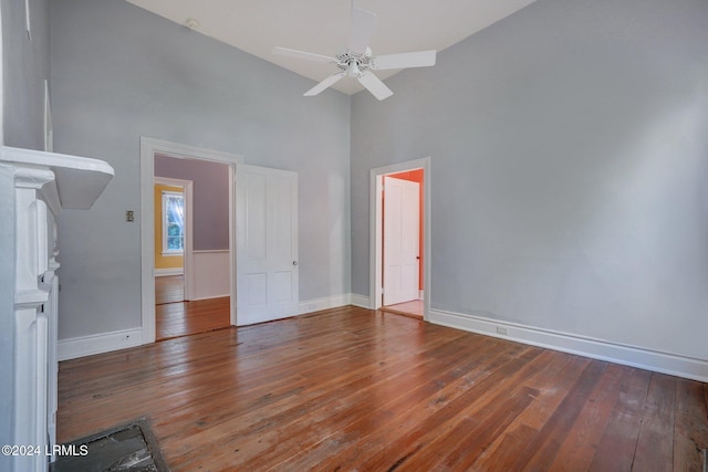 unfurnished bedroom with dark hardwood / wood-style flooring, high vaulted ceiling, and ceiling fan