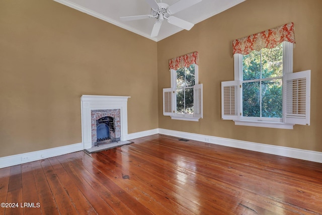 unfurnished living room with hardwood / wood-style flooring, a brick fireplace, and ceiling fan