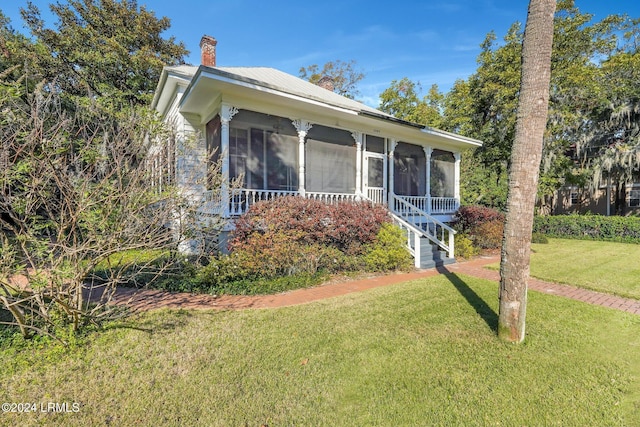 view of front of property featuring a front yard and a sunroom