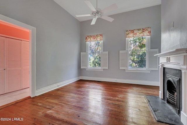 unfurnished living room featuring lofted ceiling, hardwood / wood-style flooring, and ceiling fan