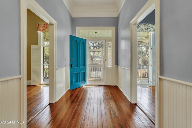 foyer entrance with plenty of natural light, ornamental molding, and dark hardwood / wood-style floors