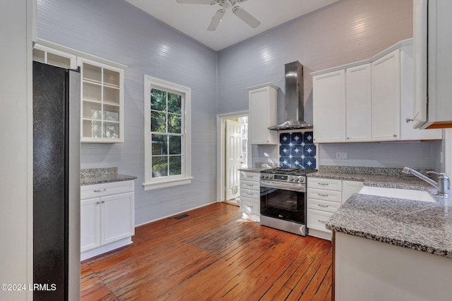 kitchen featuring stainless steel appliances, sink, white cabinets, and wall chimney exhaust hood