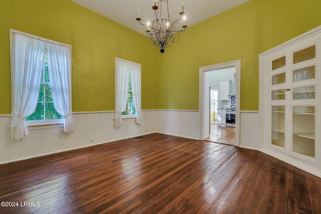 spare room featuring dark hardwood / wood-style floors and a notable chandelier