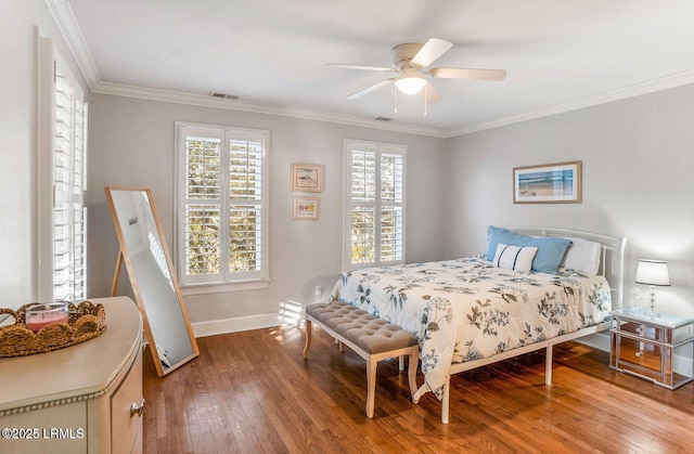 bedroom with a ceiling fan, baseboards, visible vents, hardwood / wood-style floors, and crown molding