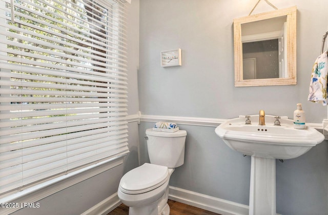 bathroom featuring wood finished floors, toilet, and baseboards