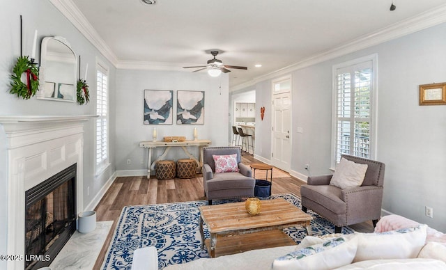 living room with a wealth of natural light, crown molding, and wood finished floors