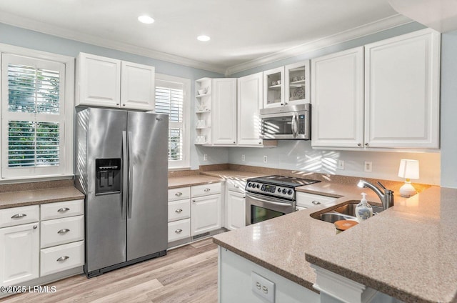 kitchen featuring stainless steel appliances, a sink, and white cabinets