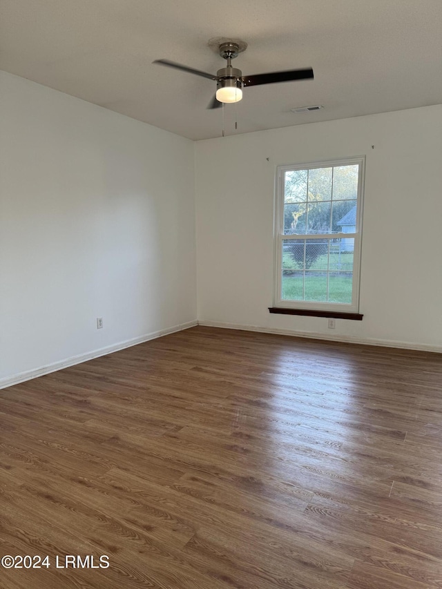 empty room featuring dark wood-type flooring and ceiling fan