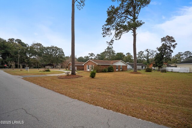 ranch-style home featuring a front lawn