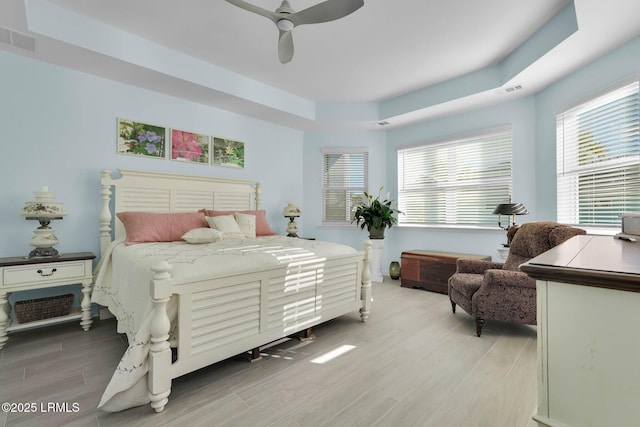 bedroom featuring a raised ceiling and ceiling fan