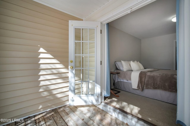 bedroom with vaulted ceiling and hardwood / wood-style floors