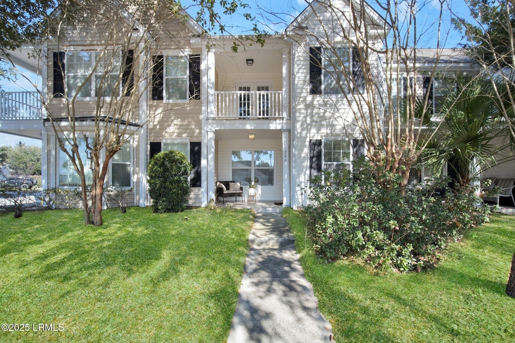 view of front of property with a front yard and a balcony