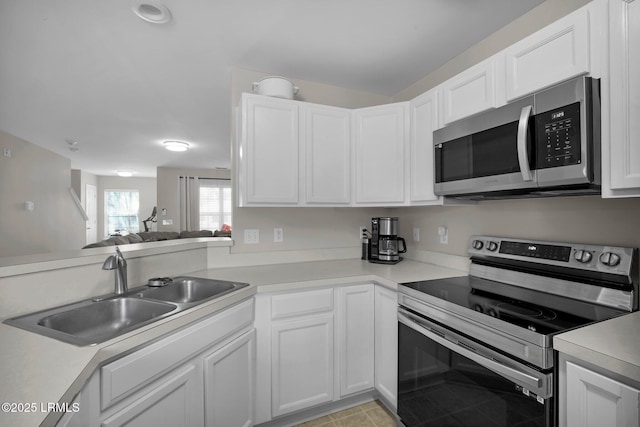 kitchen with stainless steel appliances, sink, and white cabinets