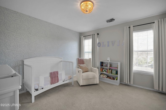 carpeted bedroom with a nursery area