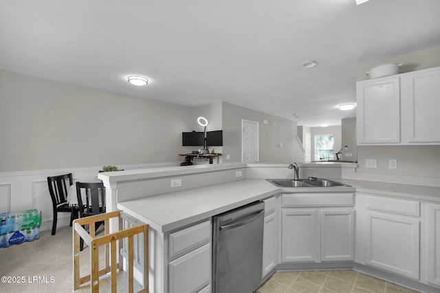 kitchen with white cabinetry, dishwasher, sink, and kitchen peninsula