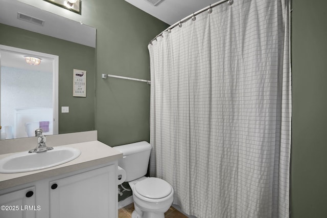 bathroom featuring vanity, toilet, and walk in shower