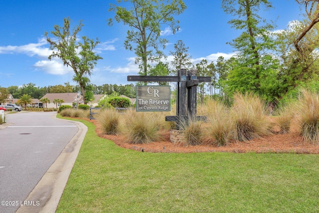 community / neighborhood sign featuring a yard