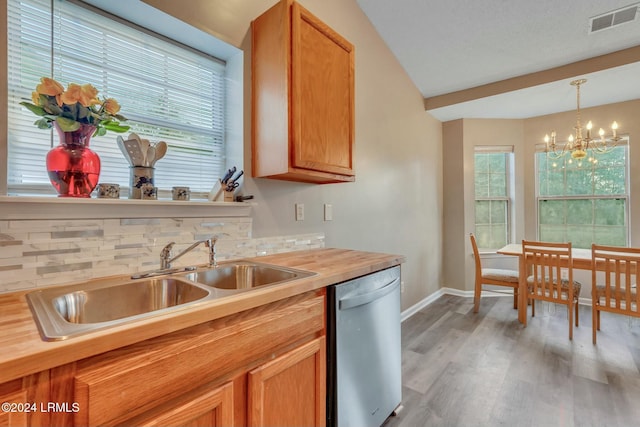 kitchen featuring wood counters, sink, hanging light fixtures, light hardwood / wood-style flooring, and dishwasher