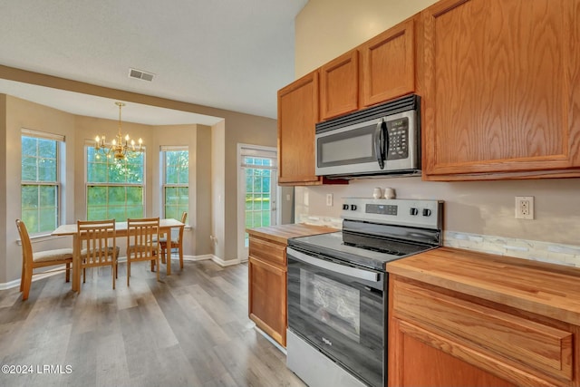 kitchen with hanging light fixtures, light hardwood / wood-style flooring, stainless steel appliances, and a chandelier