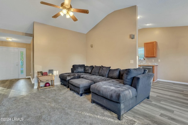 living room with ceiling fan, lofted ceiling, and light wood-type flooring