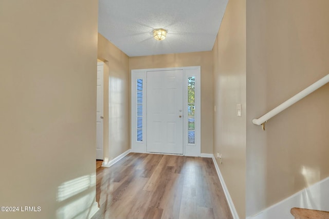 foyer entrance featuring light hardwood / wood-style floors and a textured ceiling