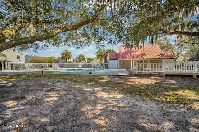 view of yard featuring a pool side deck and a patio