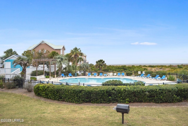 view of pool with a yard and a pergola