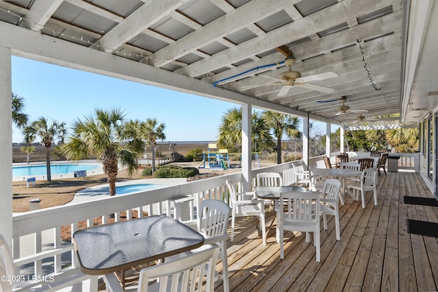 deck featuring ceiling fan and a playground