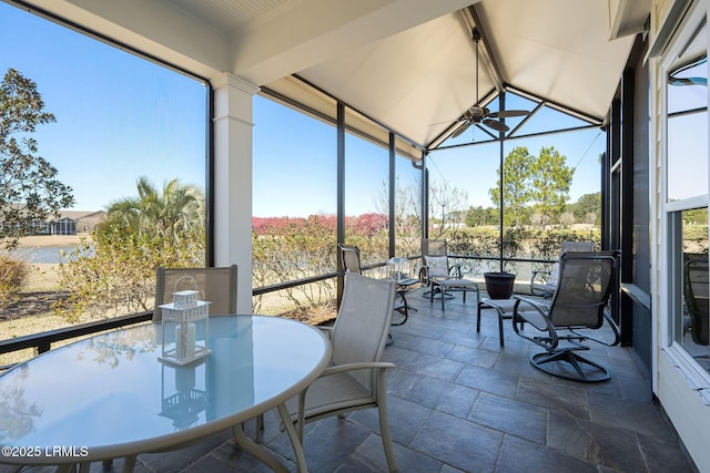 sunroom / solarium featuring a ceiling fan, lofted ceiling, and plenty of natural light