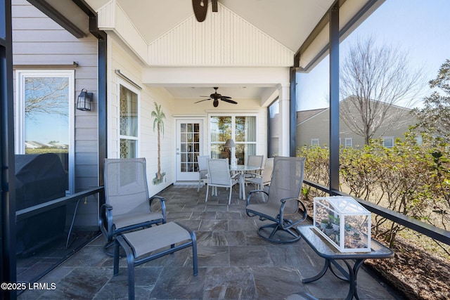 sunroom / solarium featuring lofted ceiling and ceiling fan