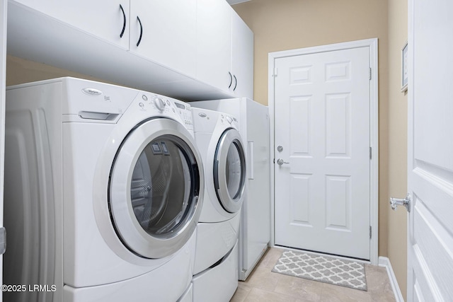 laundry area with independent washer and dryer and cabinet space